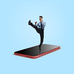 Image showing Office worker, businessman fighting on the surface of smartphone\'s screen isolated on background