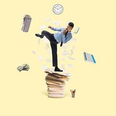 Image showing Office worker, businessman, sportsman fighting with deadlines standing on the bunch of documents