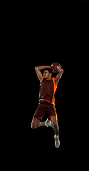 Image showing Young african basketball player training on black studio background.