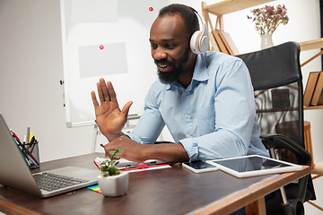 Image showing Online english courses at home. Smiling man teaches students remotely in interior of living room