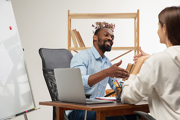 Image showing English courses at home. Smiling man teaches student in interior of living room