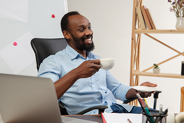 Image showing Online english courses at home. Smiling man teaches students remotely in interior of living room