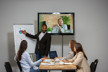 Image showing Young people talking, working during videoconference with colleagues at office or living room