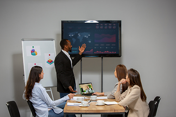 Image showing Young people talking, working during videoconference with colleagues at office or living room