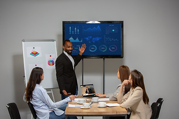 Image showing Young people talking, working during videoconference with colleagues at office or living room