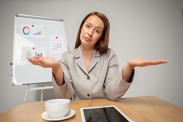 Image showing Young woman talking, working during videoconference with colleagues at home office