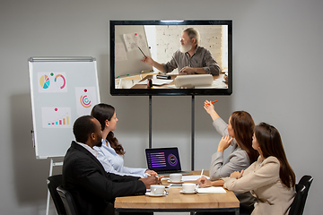Image showing Young people talking, working during videoconference with colleagues at office or living room