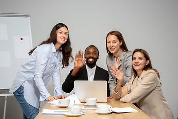 Image showing Young people talking, working during videoconference with colleagues at office or living room