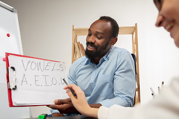 Image showing English courses at home. Smiling man teaches student in interior of living room