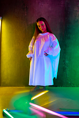 Image showing Caucasian female inclusive model posing on studio background in neon light