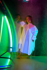 Image showing Caucasian female inclusive model posing on studio background in neon light
