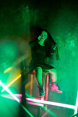 Image showing Caucasian female inclusive model posing on studio background in neon light