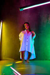 Image showing Caucasian female inclusive model posing on studio background in neon light