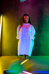 Image showing Caucasian female inclusive model posing on studio background in neon light