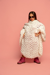 Image showing Caucasian female inclusive model posing on pink studio background in stylish outfit