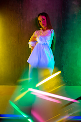 Image showing Caucasian female inclusive model posing on studio background in neon light