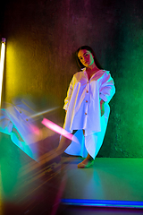 Image showing Caucasian female inclusive model posing on studio background in neon light