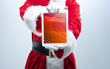 Image showing Close up hands of Santa Claus holding device with neoned decoration on the screen