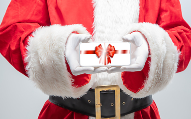 Image showing Close up hands of Santa Claus holding device with gift decoration on the screen