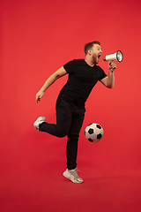 Image showing Full length portrait of young successfull jumping man gesturing isolated on red studio background
