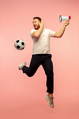 Image showing Full length portrait of young successfull high jumping man gesturing isolated on pink studio background