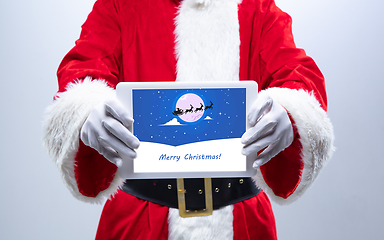Image showing Close up hands of Santa Claus holding device with postcard decoration on the screen