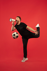 Image showing Full length portrait of young successfull jumping man gesturing isolated on red studio background