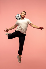 Image showing Full length portrait of young successfull high jumping man gesturing isolated on pink studio background