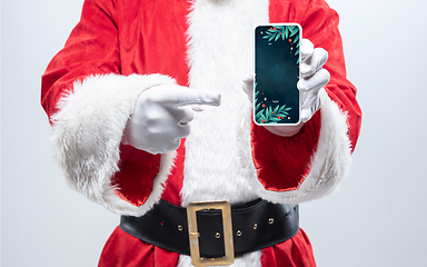 Image showing Close up hands of Santa Claus holding device with stylish decoration on the screen, copyspace