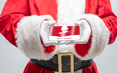 Image showing Close up hands of Santa Claus holding device with postcard decoration on the screen