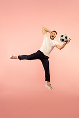 Image showing Full length portrait of young successfull high jumping man gesturing isolated on pink studio background