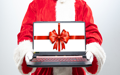 Image showing Close up hands of Santa Claus holding device with gift decoration on the screen