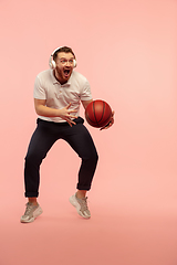 Image showing Full length portrait of young successfull high jumping man gesturing isolated on pink studio background