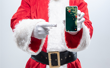 Image showing Close up hands of Santa Claus holding device with stylish decoration on the screen, copyspace