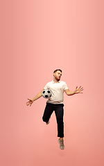 Image showing Full length portrait of young successfull high jumping man gesturing isolated on pink studio background