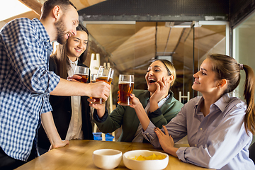 Image showing Happy co-workers celebrating corporate event after tensioned work day. Look delighted, friendly, cheerful