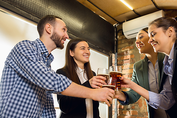 Image showing Happy co-workers celebrating corporate event after tensioned work day. Look delighted, friendly, cheerful