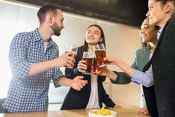 Image showing Happy co-workers celebrating corporate event after tensioned work day. Look delighted, friendly, cheerful