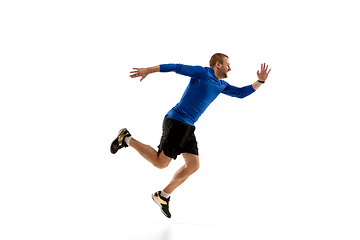 Image showing Caucasian professional runner, jogger training isolated on white studio background in fire