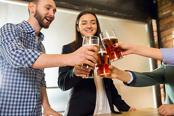 Image showing Happy co-workers celebrating corporate event after tensioned work day. Look delighted, friendly, cheerful