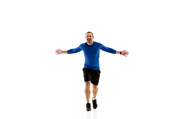 Image showing Caucasian professional runner, jogger training isolated on white studio background in fire