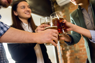 Image showing Happy co-workers celebrating corporate event after tensioned work day. Look delighted, friendly, cheerful