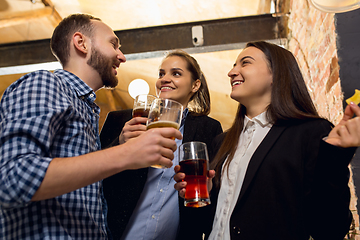 Image showing Happy co-workers celebrating corporate event after tensioned work day. Look delighted, friendly, cheerful