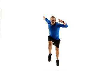 Image showing Caucasian professional runner, jogger training isolated on white studio background in fire