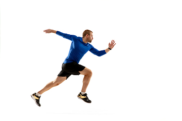 Image showing Caucasian professional runner, jogger training isolated on white studio background in fire