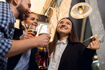 Image showing Happy co-workers celebrating corporate event after tensioned work day. Look delighted, friendly, cheerful