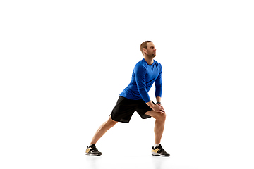 Image showing Caucasian professional runner, jogger training isolated on white studio background in fire