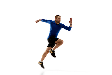 Image showing Caucasian professional runner, jogger training isolated on white studio background in fire