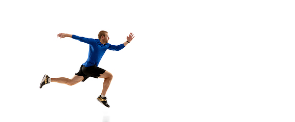 Image showing Caucasian professional runner, jogger training isolated on white studio background in fire