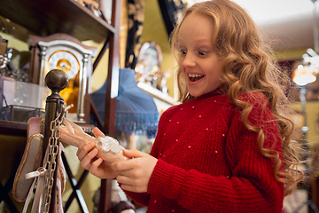 Image showing Cheerful little girl looking for home decoration and holiday\'s gifts in household store
